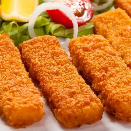 A close-up of crispy, golden-brown breaded fish sticks served next to a fresh salad with a lemon wedge
