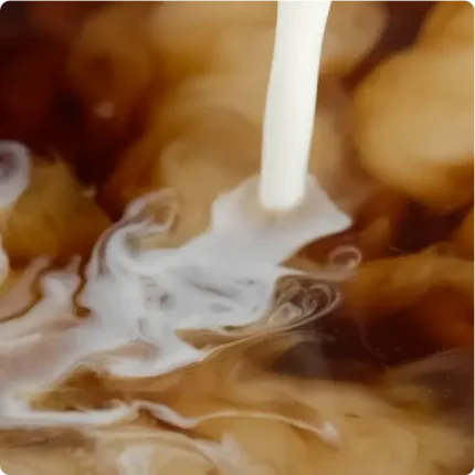 Closeup of coffee creamer being added to coffee