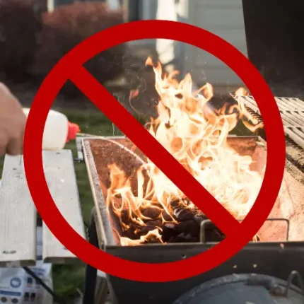 A safety warning image showing a large red "no" symbol (a circle with a diagonal slash) superimposed over a charcoal grill.