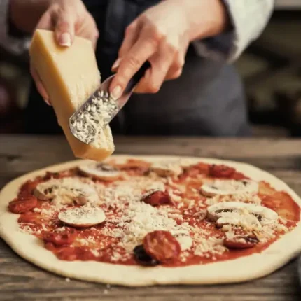 cheese being spread on a Neapolitan pizza