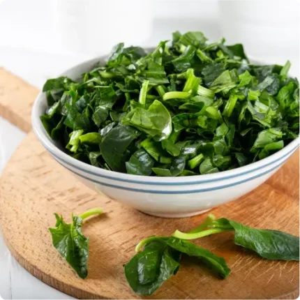 Bowl of spinach on a cutting board