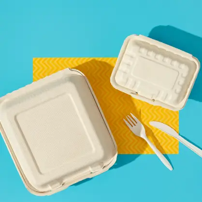 Eco-friendly disposable takeout containers and white plastic cutlery set against a bright blue and yellow background