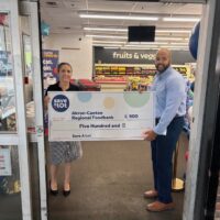 VP of Retail Operations Jerome Bouyer presents a check to the Akron-Canton Regional Foodbank