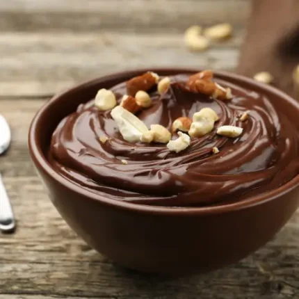 Cup of pudding with nut toppings closeup